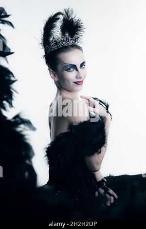 Seitenansicht der jungen Ballerina in schwarzem Tutu, Bühnenkleid und hellem Make-up, isoliert auf weißem Studio-Backgorund Stockfoto