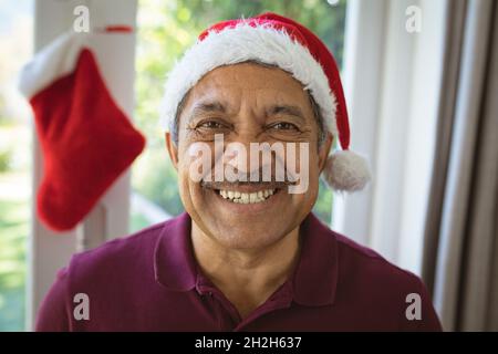 Porträt eines glücklichen Senioren aus dem Biracial zu weihnachten im Weihnachtshut Stockfoto