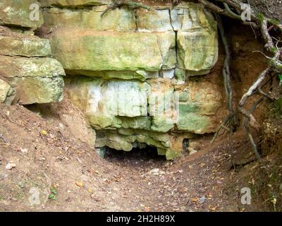 Eingang zu einer kleinen Höhle, im Sommer Stockfoto