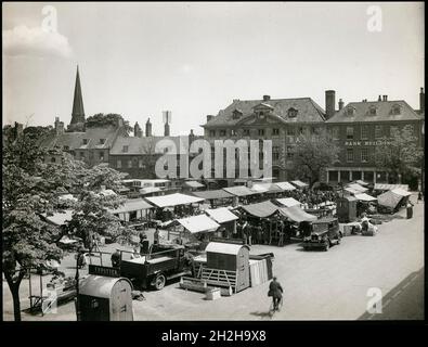 Tuesday Market Place, Kings Lynn, King's Lynn und West Norfolk, Norfolk, 1925-1935. Dienstag Market Place von der Südwestecke aus gesehen, mit Leuten, die im Vordergrund Marktstände durchstöberten und den Nummern 4-10, einschließlich des Duke's Head Hotels und des Turms der St. Nicholkkapelle, im Hintergrund. Stockfoto