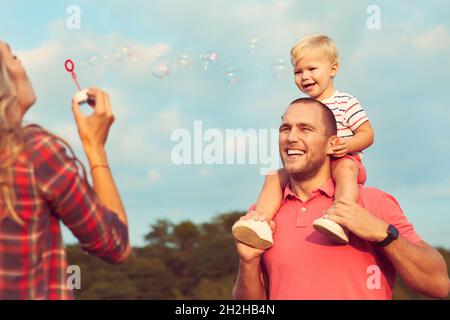 Kind Familie im Freien Mutter Frau Vater Junge Sohn glücklich Glück Lebensstil mit Spaß Seifenblase Stockfoto