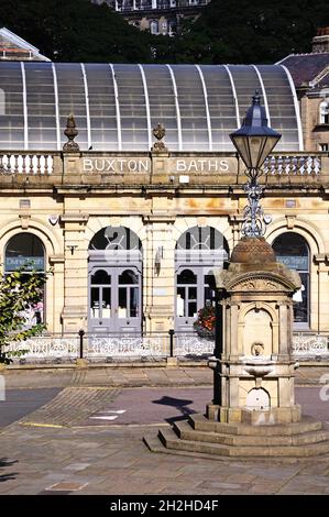 Blick auf die Thermalbäder (jetzt Cavendish Einkaufspassage) mit einem Trinkbrunnen und einer Straßenlaterne im Vordergrund, Buxton, Derbyshire, England, Großbritannien, Stockfoto