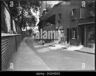 Collingwood Street, Blackfriars, Southwark, Greater London Authority, 1930er Jahre. Ein Blick nach Nordosten entlang der Collingwood Street, der Figuren zeigt, die an verwitterten Hütten auf der Ostseite der Straße vorbeigehen. Diese Straße heißt jetzt Colombo Street. Die Hütten wurden 1948 abgerissen, nachdem sie während des Zweiten Weltkriegs durch Bombenangriffe beschädigt wurden. Stockfoto