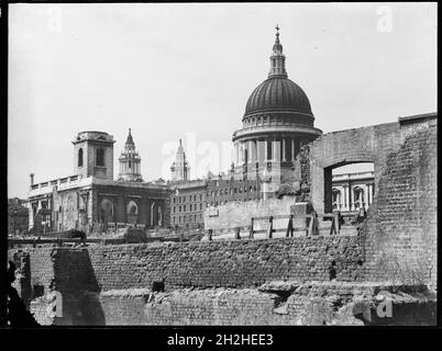 St Paul's Cathedral, St Paul's Churchyard, City of London, City and County of the City of London, Greater London Authority, 1941-1945. Blick nach Nordwesten über eine durch Bomben beschädigte Landschaft zur St. Paul's Cathedral mit der St. Nichola Cole Abbey links im Vordergrund. Die St. Nichola Cole Abbey wurde von Christopher Wren nach dem großen Brand von London im Jahr 1666 wieder aufgebaut. Während des Zweiten Weltkriegs wurde es durch Bombenangriffe erneut schwer beschädigt und lag in Trümmern, bis es 1962 restauriert wurde. Stockfoto