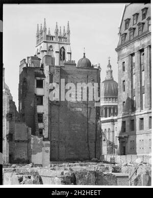 St Paul's Cathedral, St Paul's Churchyard, City of London, City and County of the City of London, Greater London Authority, 1941-1945. Ein Blick aus dem Nordosten, der die Kuppel der St. Paul's Cathedral durch eine Lücke zwischen Gebäuden zeigt, wobei die Spitze des Turms der St. Alban's Church in der Wood Street hinter einem bombenbeschädigten Gebäude im Vordergrund steht. St. Alban's Church wurde von Christopher Wren nach dem großen Brand von London im Jahr 1666 wieder aufgebaut. Während des Zweiten Weltkriegs wurde es durch Bombenangriffe zerstört, wobei nur der Turm überlebte. Stockfoto