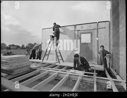 Arbeiter, die ein schwedisches Fertighaus zusammenbauen, mit einem individuellen Beratungsplan im Vordergrund, 1945. Es ist schwierig festzustellen, wo genau diese schwedischen Häuser gebaut wurden. Allerdings wurden die ersten schwedischen Häuser in Großbritannien in Abbots Langley, Hertfordshire, irgendwann auf (oder in der Nähe) Trowley Rise gebaut. Stockfoto