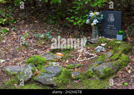 Hundegrab auf dem Hundefriedhof in Portmeirion, Gwynedd, Wales - Roger, unser lieber Freund, der diese Wälder liebte, wird seinen strahlenden Geist leider vermissen Stockfoto