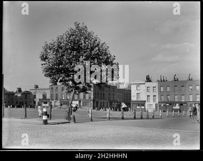 Cumberland Market, Regents Park, Camden, Greater London Authority, 1930er Jahre. Ein Blick nach Nordosten über den Cumberland Market in Richtung Edward Street und Reihenhäuser und leerstehende Geschäfte auf der Ostseite des Platzes. Cumberland Market war ein Heu- und Strohmarkt vom frühen 19. Jahrhundert bis in die späten 1920er Jahre. In den frühen 1930er Jahren wurden Gebäude in der Gegend abgerissen, um Platz für die unterbringung des rates zu schaffen, und noch mehr von der Gegend wurde durch Bombardierungen im Zweiten Weltkrieg zerstört. Die übrigen Gebäude wurden 1950-51 abgerissen und das Regent's Park Estate wurde auf dem Gelände errichtet. Stockfoto