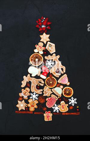Weihnachtsbaum aus Lebkuchen und Gewürzen auf dunklem Grund. Speicherplatz kopieren. Neujahrs- und Weihnachtskarte. Stockfoto