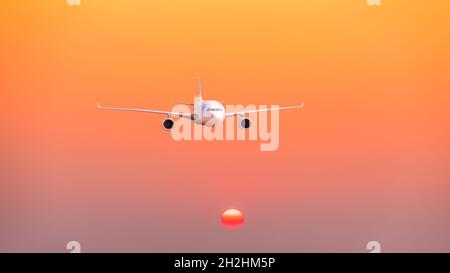 Verkehrsflugzeug, das bei Sonnenuntergang über Wolken fliegt. Stockfoto