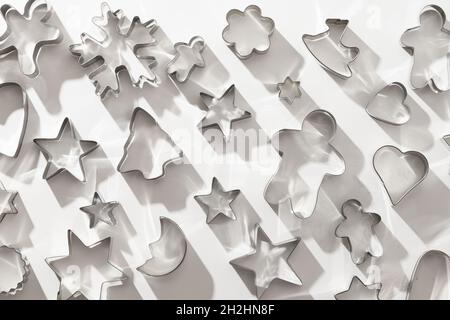 Weihnachtliche Ausstechformen für traditionelle Lebkuchen auf weißem Hintergrund als Muster. Weihnachten kreatives Konzept und Grußkarte. Draufsicht, flach la Stockfoto