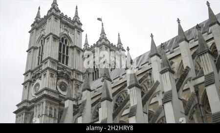 Blick von unten auf die Westminster Abbey von außen Details gegen den grau bewölkten Himmel. Es handelt sich um eine große, hauptsächlich gotische Abteikirche in der Stadt W Stockfoto