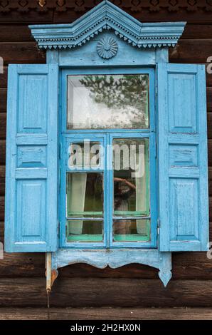 Blaues Fenster mit Fensterläden eines traditionellen Holzhauses im Ethnographischen Museum in der Nähe von Ulan-Ude. Republik Burjatien, Russland Stockfoto