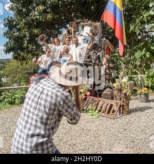 Traditionelles Festival von Salento: Touristen posieren auf einem Set mit traditioneller kolumbianischer Kleidung vor dem Fotografen. Salento, Kolumbien Stockfoto