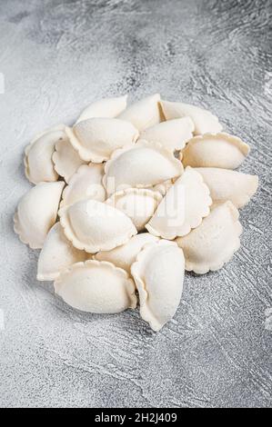 Rohe gefrorene Knödel pierogi auf einem Küchentisch. Weißer Hintergrund. Draufsicht Stockfoto