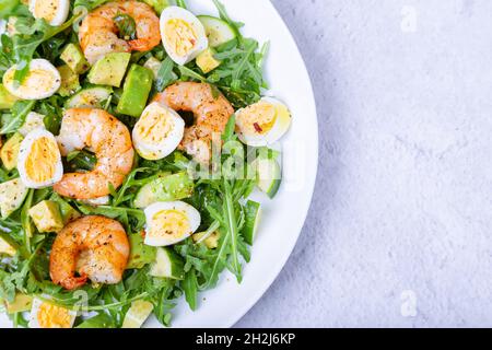 Salat mit Garnelen, Avocado, Gurken, Wachteleiern und Rucola. Traditionelle mediterrane Küche. Nahaufnahme. Stockfoto