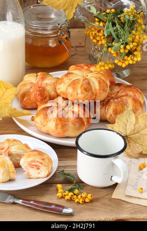 Kürbisbrötchen mit Milch und Honig auf Holzboden Stockfoto