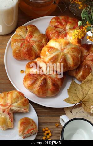 Kürbisbrötchen mit Milch und Honig auf Holzboden Stockfoto