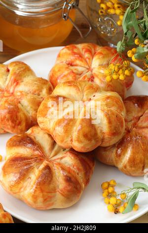 Kürbisbrötchen mit Milch und Honig auf Holzboden Stockfoto