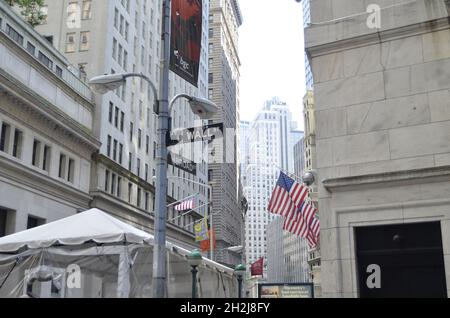 Wall Street Schild und amerikanische Fahnen im Hintergrund Stockfoto