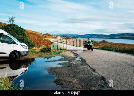 Ein Wohnmobil und ein Motorrad auf der NC500 Road Trip in schottland mit Panoramablick auf Berge und Seen Stockfoto