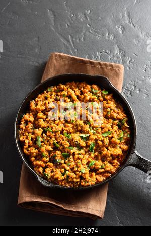 Keema-Kerk in Bratpfanne auf schwarzem Stein-Hintergrund mit freiem Textbereich. Indische und pakistanische Gerichte. Stockfoto