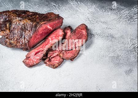 Gebratener Aufhänger oder Onglet-Rindersteak in Scheiben auf einem Tisch. Weißer Hintergrund. Draufsicht. Speicherplatz kopieren Stockfoto