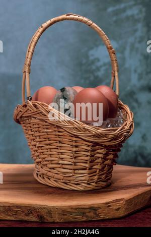 Ein Weidenkorb enthält Eier, von denen eines aus vulkanischem Stein besteht Stockfoto