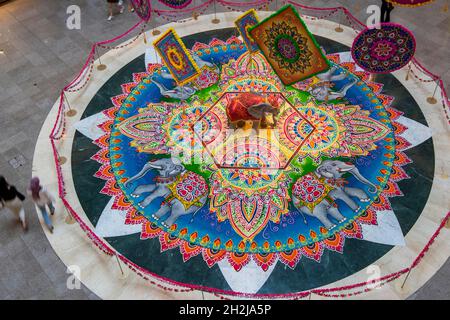 Kuala Lumpur, Malaysia. Oktober 2021. Menschen gehen in der Nähe von Kolam, einer traditionellen Kunstform, die für das bevorstehende Diwali-Festival in Kuala Lumpur, Malaysia, am 22. Oktober 2021, gemacht wurde. Quelle: Chong Voon Chung/Xinhua/Alamy Live News Stockfoto