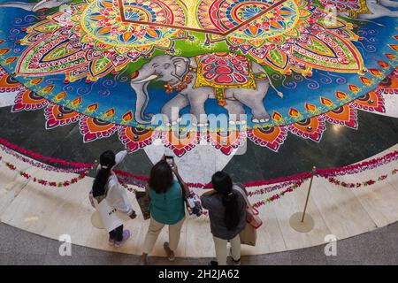 Kuala Lumpur, Malaysia. Oktober 2021. Die Menschen fotografieren einen Kolam, eine traditionelle Kunstform, die für das bevorstehende Diwali-Festival in Kuala Lumpur, Malaysia, am 22. Oktober 2021, gemacht wurde. Quelle: Chong Voon Chung/Xinhua/Alamy Live News Stockfoto