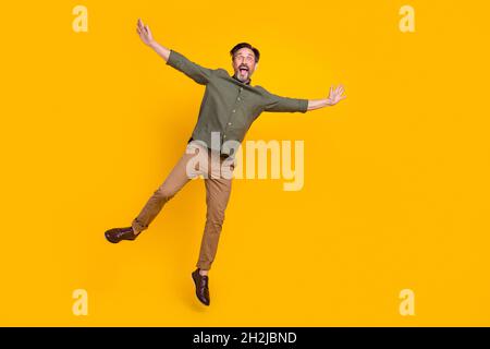 In voller Länge Körpergröße Ansicht der attraktiven fröhlich lustigen Mann springen Spaß isoliert über hellen gelben Hintergrund Stockfoto