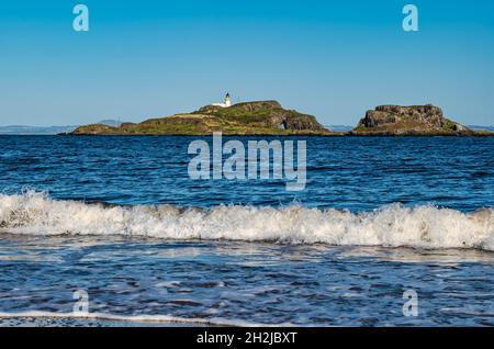 Wellenbrecher am Yellowcraig Strand mit Blick auf den Leuchtturm der Fidra Insel an sonnigen Tagen, East Lothian, Schottland, Großbritannien Stockfoto