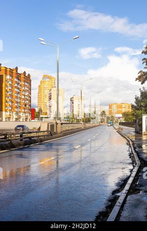 Moskau, Russland - 4. September 2021: Blick auf die nasse Fahrbahn der Bolshaya Akademitscheskaya Straße im Koptevo Bezirk der Moskauer Stadt nach Regen auf sonnigem Autu Stockfoto