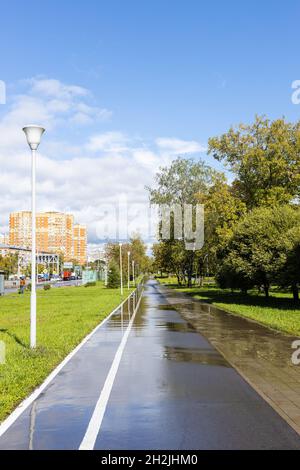 Nasser Bürgersteig mit Radweg entlang Bolshaya Akademitscheskaya Straße im Koptevo Bezirk der Moskauer Stadt nach Regen am sonnigen Herbsttag Stockfoto