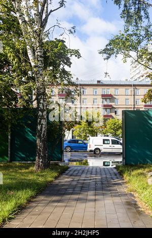 Die Tore in der Lärmschutzmauer der Straße Bolschaja Akademitscheskaja der Straße im Koptewo Bezirk der Moskauer Stadt nach dem Regen am sonnigen Herbsttag Stockfoto