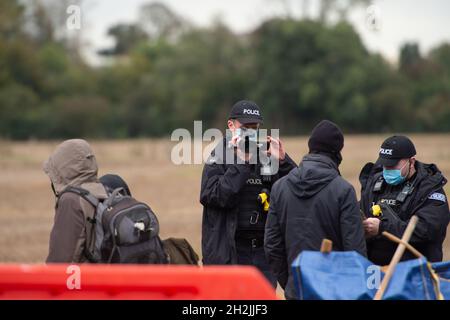 Chalfont St Peter, Großbritannien. Oktober 2021. Stopp HS2-Demonstranten aus dem Kriegslager Wendover aktiver Widerstand besetzten einen Bagger, der heute vor dem Gelände des HS2 Chalfont St Peter Hochwasserschutzarbeiten durchführte, wo die Überschwemmungen auf der Straße angeblich viel schlimmer wurden, seitdem HS2 vor Ort Bäume und Felder geräumt hat. Die Demonstranten gingen freiwillig, als das reguläre Thames Valley Police Team, das HS2 arbeitet, eintraf. Quelle: Maureen McLean/Alamy Live News Stockfoto