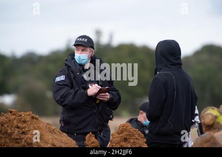 Chalfont St Peter, Großbritannien. Oktober 2021. Stopp HS2-Demonstranten aus dem Kriegslager Wendover aktiver Widerstand besetzten einen Bagger, der heute vor dem Gelände des HS2 Chalfont St Peter Hochwasserschutzarbeiten durchführte, wo die Überschwemmungen auf der Straße angeblich viel schlimmer wurden, seitdem HS2 vor Ort Bäume und Felder geräumt hat. Die Demonstranten gingen freiwillig, als das reguläre Thames Valley Police Team, das HS2 arbeitet, eintraf. Quelle: Maureen McLean/Alamy Live News Stockfoto