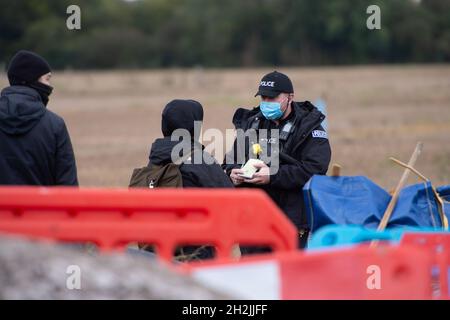 Chalfont St Peter, Großbritannien. Oktober 2021. Stopp HS2-Demonstranten aus dem Kriegslager Wendover aktiver Widerstand besetzten einen Bagger, der heute vor dem Gelände des HS2 Chalfont St Peter Hochwasserschutzarbeiten durchführte, wo die Überschwemmungen auf der Straße angeblich viel schlimmer wurden, seitdem HS2 vor Ort Bäume und Felder geräumt hat. Die Demonstranten gingen freiwillig, als das reguläre Thames Valley Police Team, das HS2 arbeitet, eintraf. Quelle: Maureen McLean/Alamy Live News Stockfoto