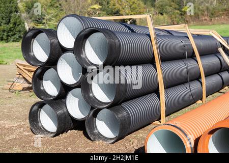 Stapel von Polyethylen-Entwässerungsrohren auf der Baustelle Stockfoto