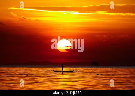 Pasay, National Capital Region, Philippinen. Oktober 2021. Ein Mann, der kurz vor dem Sonnenuntergang auf einem Boot mit seiner Angelrute steht. (Bild: © George Buid/ZUMA Press Wire) Bild: ZUMA Press, Inc./Alamy Live News Stockfoto