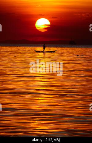 Pasay, National Capital Region, Philippinen. Oktober 2021. Ein Mann, der kurz vor dem Sonnenuntergang auf einem Boot mit seiner Angelrute steht. (Bild: © George Buid/ZUMA Press Wire) Stockfoto