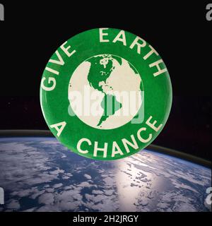 Ein zusammengesetztes Bild eines 1970 Green Earth Day Buttons, der über dem Planeten Erde schwebt Stockfoto