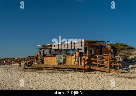 Es Trenc, Spanien; oktober 11 2021: Allgemeine Ansicht einer Strandbar bei Sonnenuntergang, mit Touristen in der Einrichtung. Es Trenc Strand, Insel Mallorca, Spanien Stockfoto