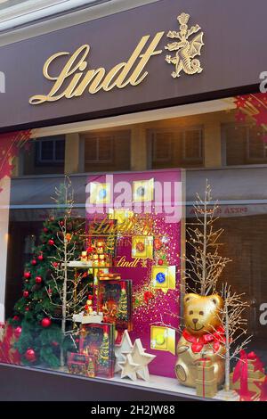 Außenansicht des traditionellen Schweizer Lindt-Schokoladenladens, geschmückt zu Weihnachten, in Düsseldorf, Deutschland. Stockfoto