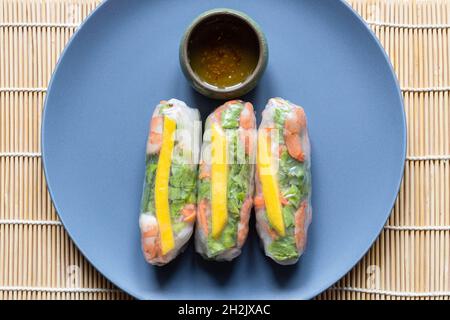 Draufsicht auf einen Teil von Nem Cuon, vietnamesische Frühlingsrollen auf graublauem Teller Stockfoto