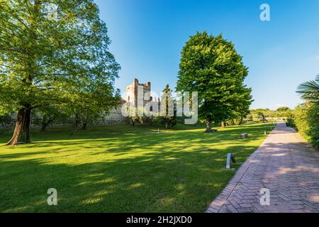 Öffentlicher Park und die mittelalterliche Umbaumauer des kleinen Dorfes Lazise, Ferienort an der Küste des Gardasees. Verona, Venetien, Italien. Stockfoto