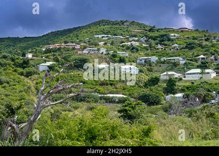 Bedrohliche dunkle Regenwolke über Häusern auf einem Hügel auf der Ostseite der niederländischen Insel Sint Maarten in der Karibik Stockfoto