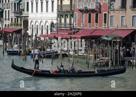 VENEDIG, ITALIEN - 13. Okt 2013: Traditionelle Gondel mit Passagieren auf dem Canal Grande in der Nähe der Rialtobrücke, Italien Stockfoto