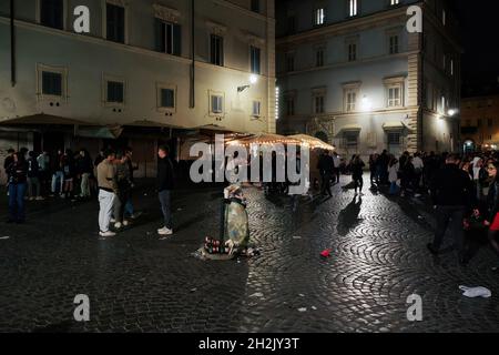 Rom, Italien - Oktober 10 2021: Müllbeutel voller Müll bei Trastevere. Müll draußen vor einem durchsichtigen Müllcontainer auf einem öffentlichen Platz der römischen Hauptstadt mit Menschenmengen in der Nacht. Stockfoto