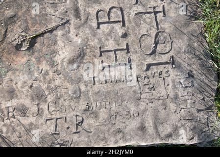 Namen und Daten, die am Fuß des Fahnenmastes, der sich auf dem Gipfel des Caastlebergh Hill in Settle befindet, in Stein gemeißelt sind Stockfoto